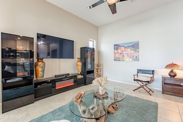 tiled living area featuring baseboards and ceiling fan