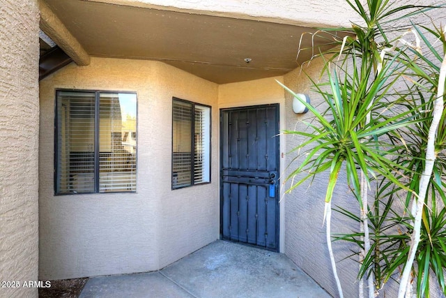 entrance to property featuring stucco siding