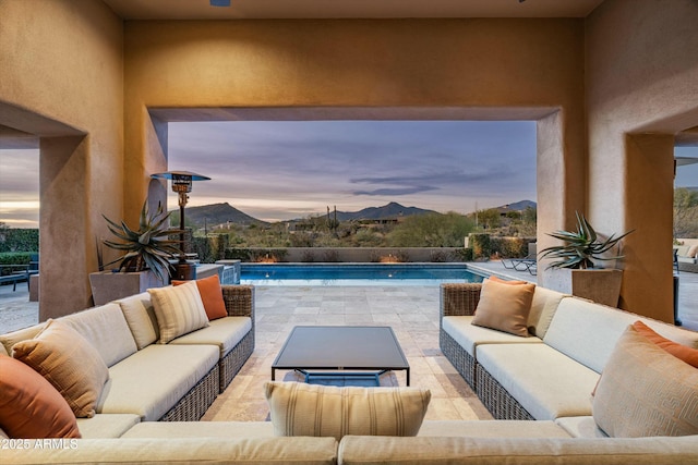 exterior space featuring a fenced in pool, a patio area, outdoor lounge area, and a mountain view