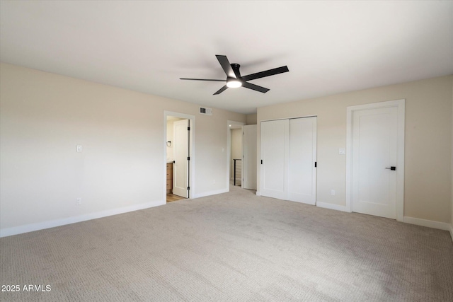 unfurnished bedroom with visible vents, light colored carpet, ensuite bathroom, and baseboards