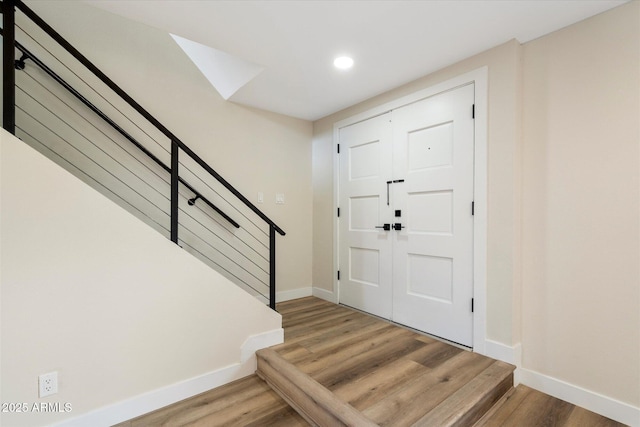 entryway with light wood finished floors, stairway, recessed lighting, and baseboards