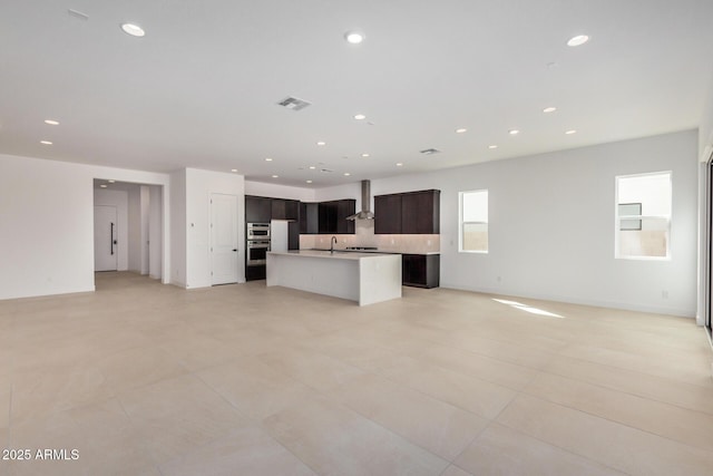 kitchen featuring a kitchen island with sink, recessed lighting, a sink, visible vents, and open floor plan