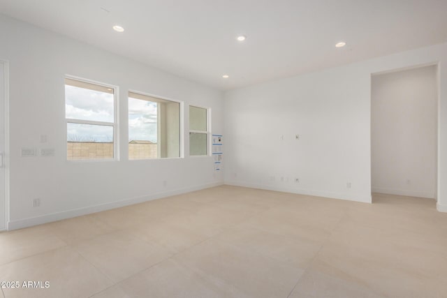 spare room with baseboards and recessed lighting