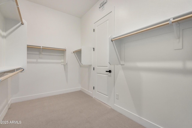 walk in closet featuring light carpet