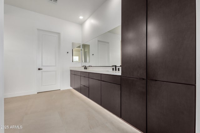 bathroom featuring recessed lighting, a sink, baseboards, tile patterned floors, and double vanity