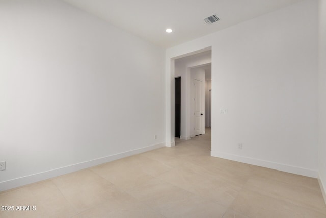 empty room with recessed lighting, visible vents, and baseboards