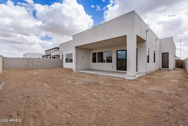 rear view of house featuring a patio area, a fenced backyard, and stucco siding