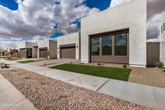 view of front of home featuring a garage, driveway, and stucco siding