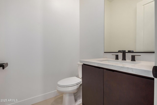 bathroom featuring baseboards, vanity, toilet, and tile patterned floors