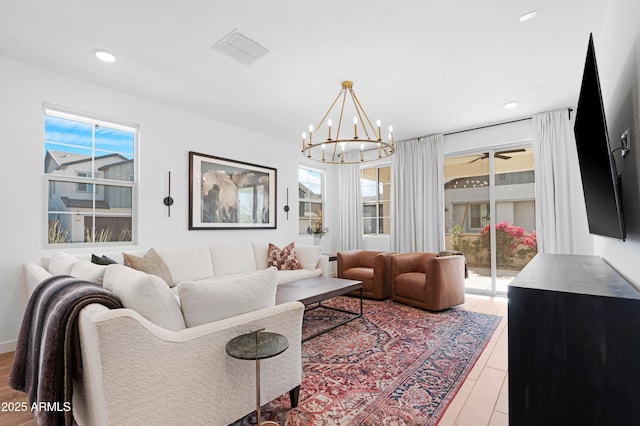 living room with wood-type flooring, an inviting chandelier, and a wealth of natural light