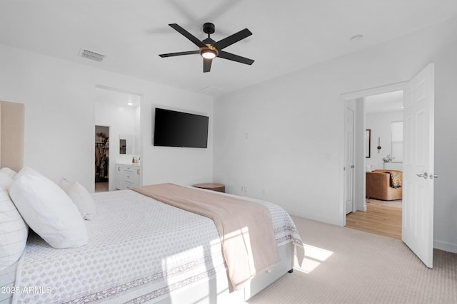 carpeted bedroom featuring ceiling fan and ensuite bathroom