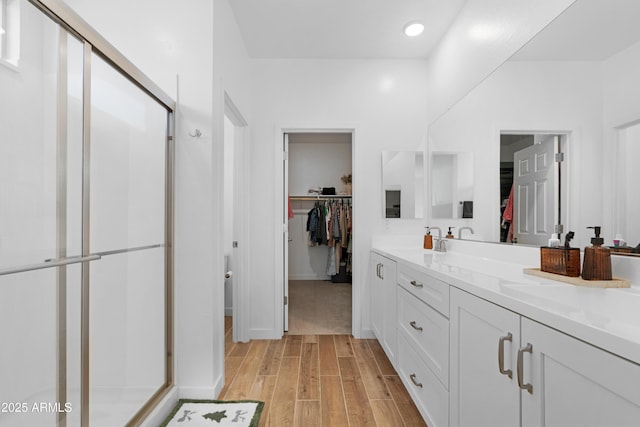 bathroom with a shower with door and vanity