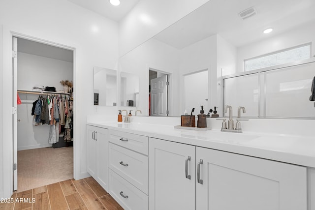 bathroom with vanity and a shower with shower door