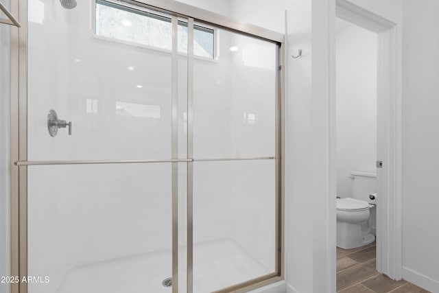 bathroom featuring toilet and an enclosed shower