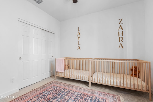 bedroom featuring ceiling fan, a closet, and a nursery area