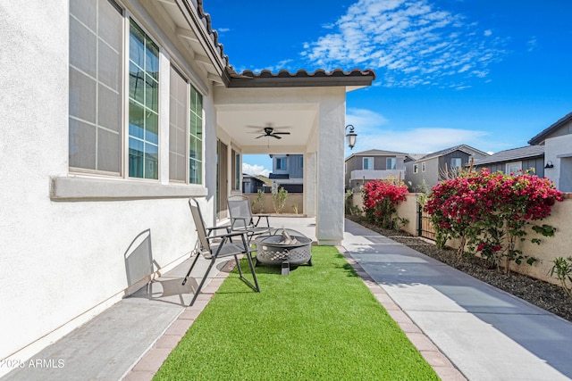 view of patio / terrace with ceiling fan and a fire pit