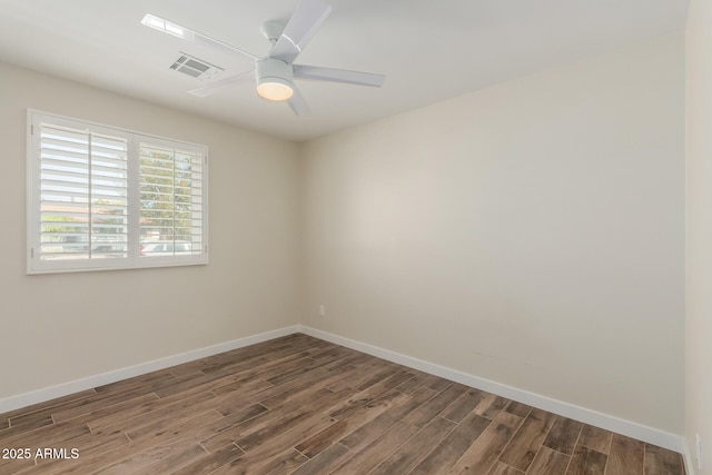 unfurnished room with a ceiling fan, visible vents, baseboards, and wood finished floors