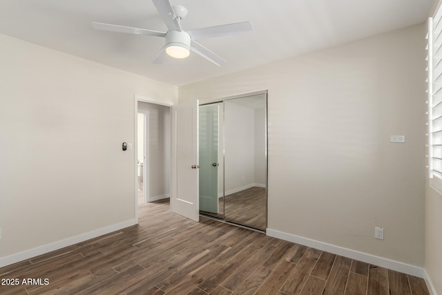 unfurnished bedroom featuring dark wood-type flooring, a closet, a ceiling fan, and baseboards