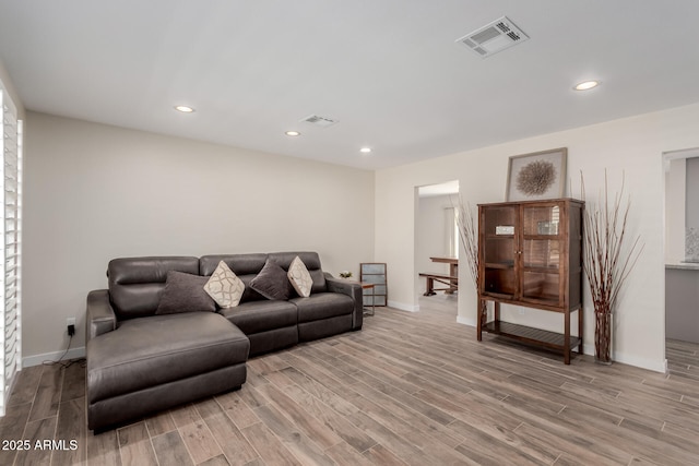 living area featuring light wood-style floors, recessed lighting, and visible vents