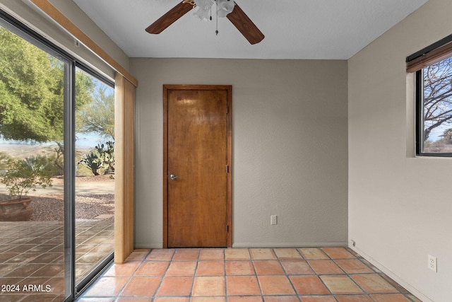 tiled spare room featuring ceiling fan