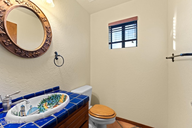 bathroom featuring tile patterned floors, vanity, and toilet