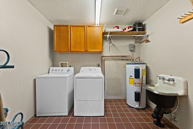 clothes washing area featuring separate washer and dryer, electric water heater, cabinets, and a textured ceiling