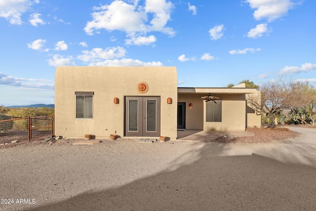 pueblo revival-style home featuring ceiling fan, a patio, and french doors