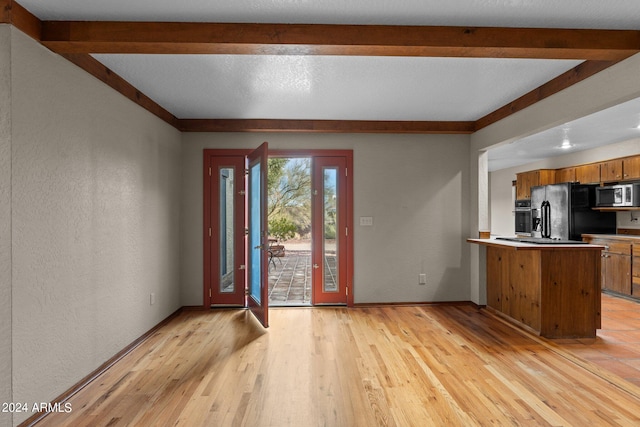 foyer entrance with beam ceiling and light wood-type flooring