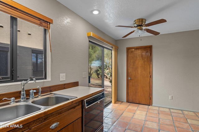 kitchen with a textured ceiling, ceiling fan, sink, light tile patterned floors, and black dishwasher