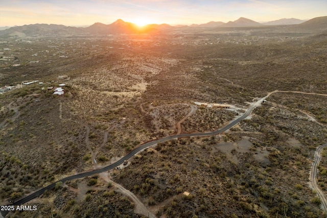 aerial view at dusk featuring a mountain view