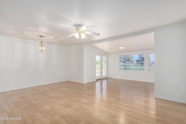 spare room with baseboards, vaulted ceiling, french doors, a ceiling fan, and light wood-style floors