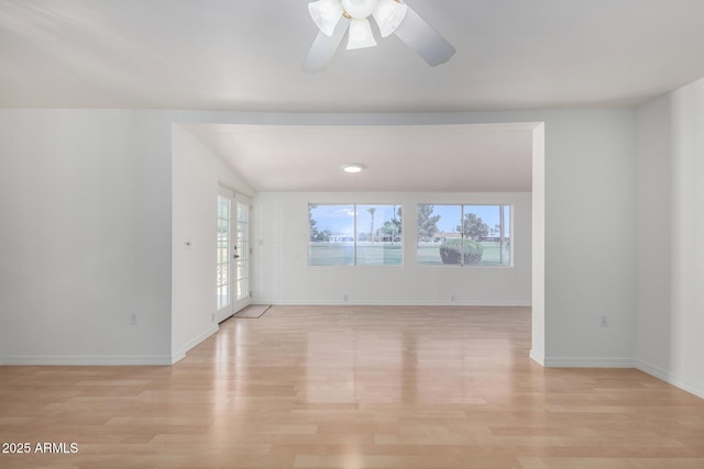empty room with light wood-style floors, baseboards, a ceiling fan, and french doors