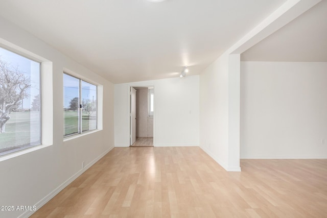unfurnished room with light wood-type flooring and baseboards