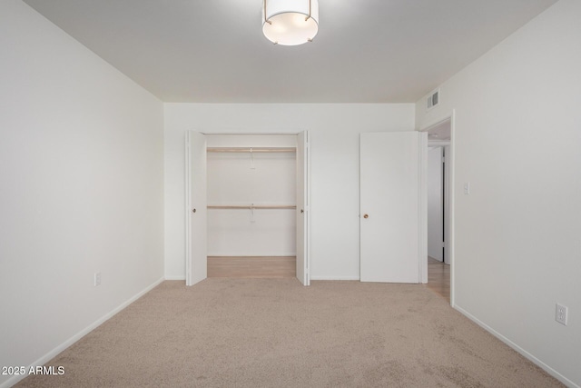 unfurnished bedroom with visible vents, baseboards, a closet, and carpet floors