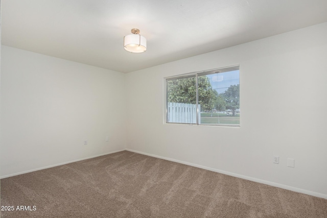carpeted empty room with baseboards