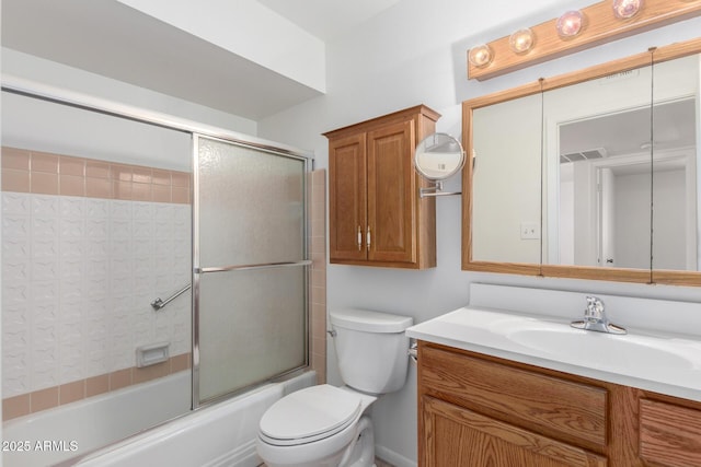 bathroom featuring visible vents, toilet, vanity, and bath / shower combo with glass door