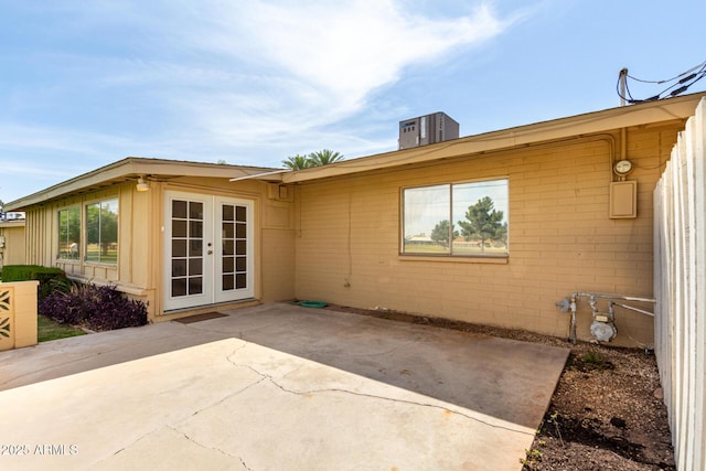back of house featuring cooling unit, a patio, french doors, and brick siding