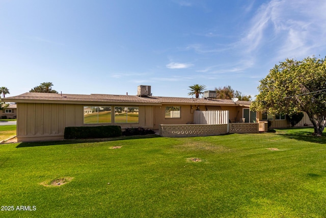 rear view of house with a yard and cooling unit