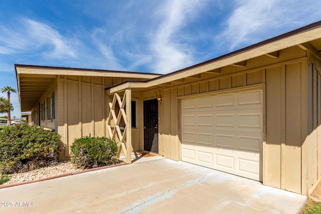 view of front facade with board and batten siding, driveway, and a garage