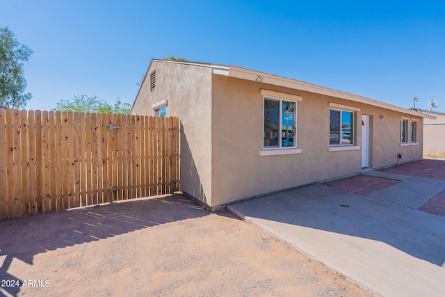 view of front of property featuring a patio area, fence, and stucco siding