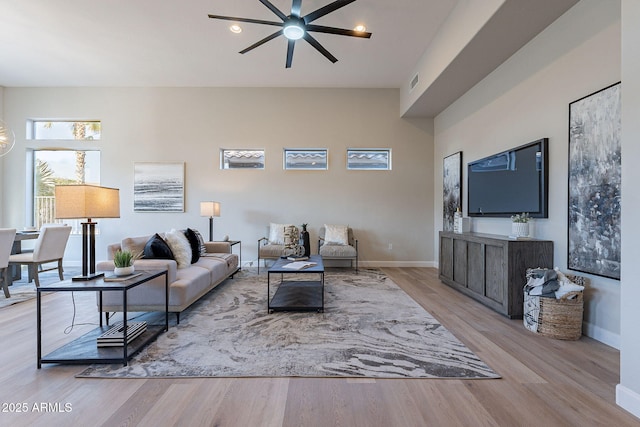 living room featuring ceiling fan and light hardwood / wood-style floors