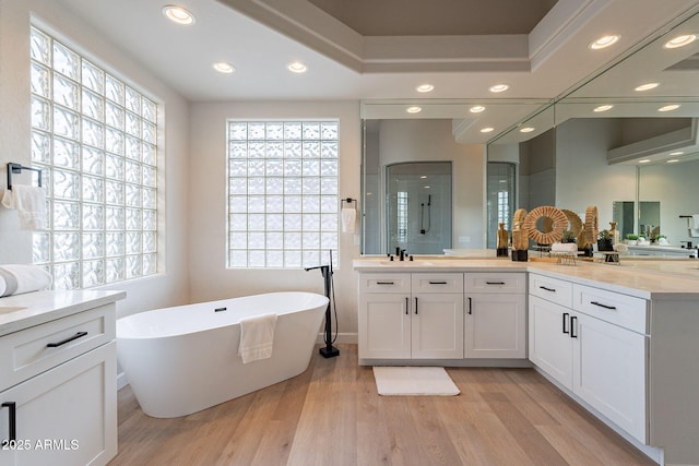 bathroom with hardwood / wood-style floors, vanity, and independent shower and bath