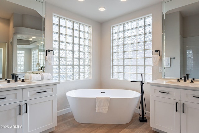 bathroom with a bathing tub, vanity, and hardwood / wood-style flooring