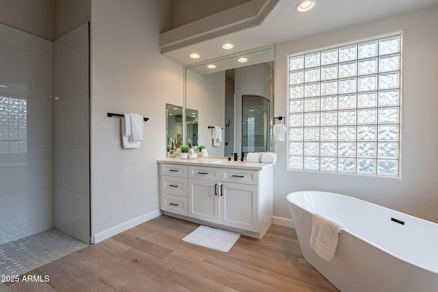 bathroom with wood-type flooring, vanity, and shower with separate bathtub