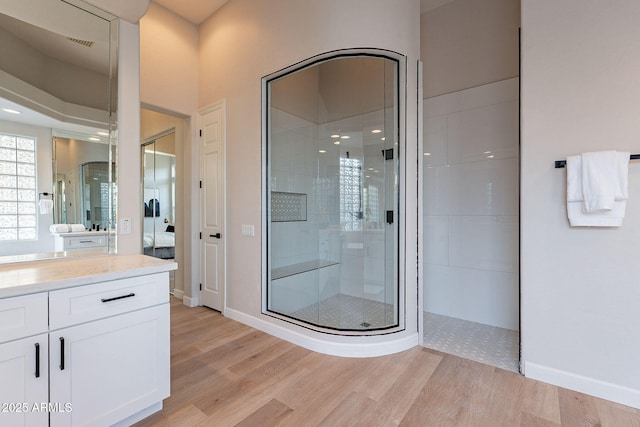 bathroom with hardwood / wood-style floors, vanity, and an enclosed shower