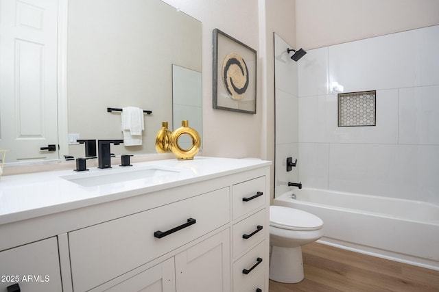 full bathroom with hardwood / wood-style floors, vanity, toilet, and tiled shower / bath