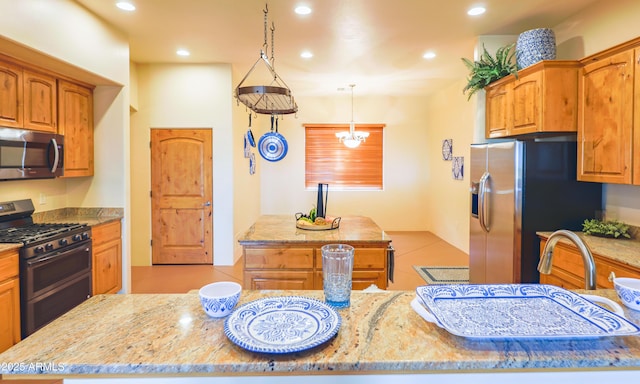 6754 E Roberto Loop, Hereford, AZ 85615 - kitchen with appliances with stainless steel finishes, light stone counters, recessed lighting, a center island, and brown cabinetry