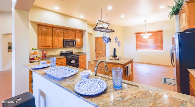 6754 E Roberto Loop, Hereford, AZ 85615 - kitchen featuring stainless steel appliances, light stone countertops, brown cabinetry, and recessed lighting