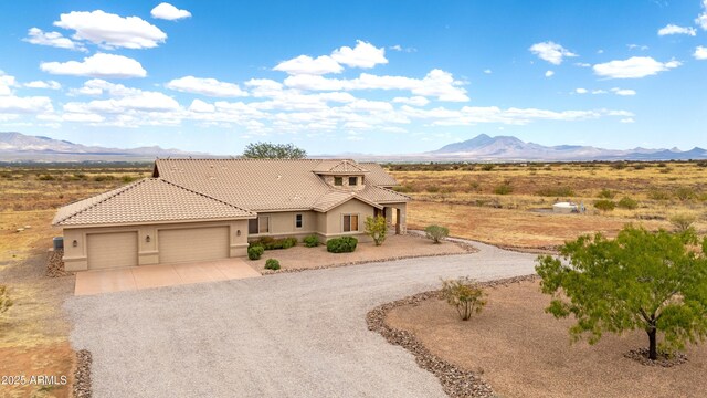 6754 E Roberto Loop, Hereford, AZ 85615 - view of front of property featuring driveway, a mountain view, stucco siding, a tiled roof, and a garage