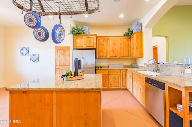 6754 E Roberto Loop, Hereford, AZ 85615 - kitchen featuring stainless steel appliances, a kitchen island, light stone countertops, a sink, and arched walkways